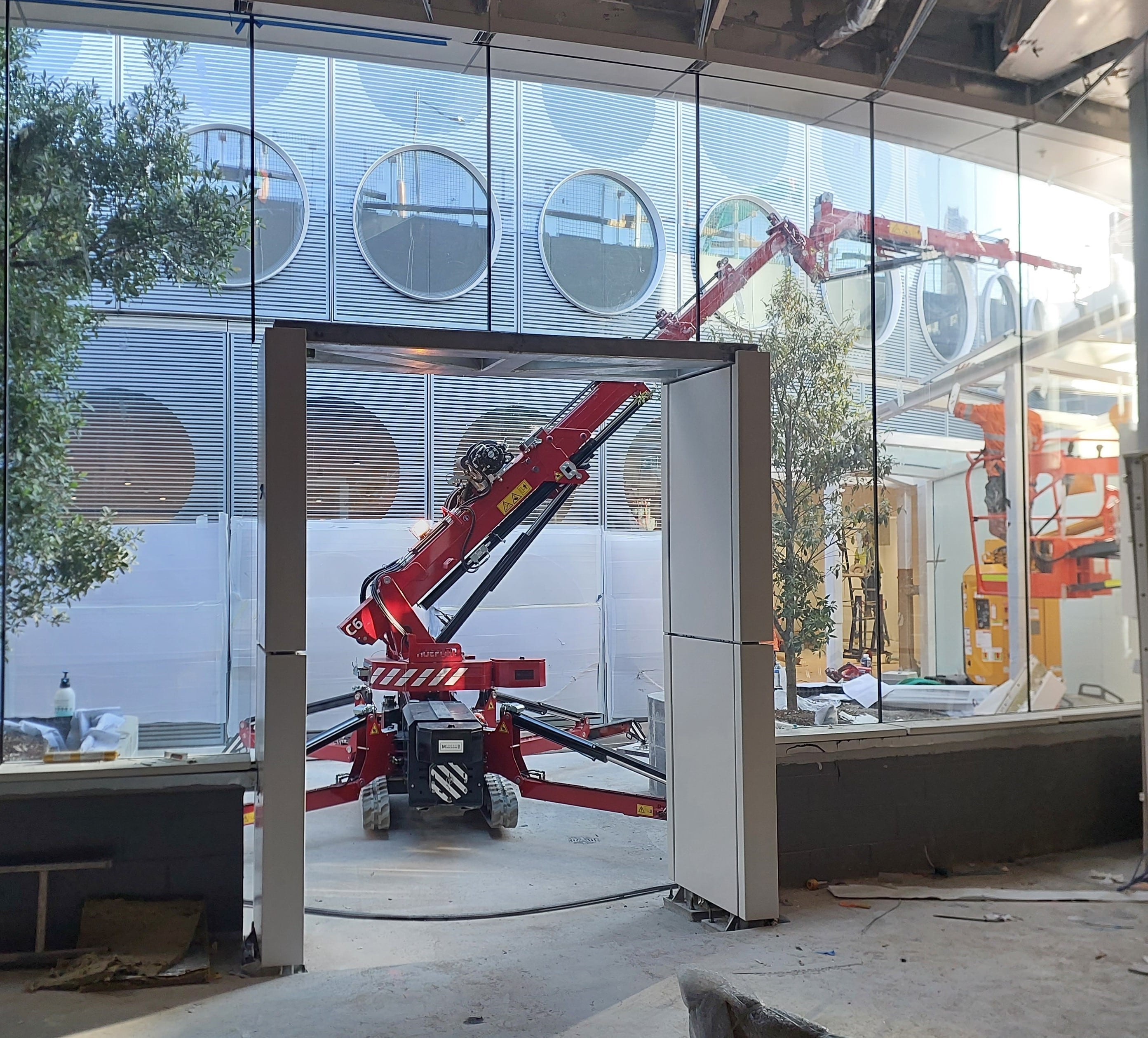 Hoeflon c6 operating in confined space with flyjib operating over a tree.