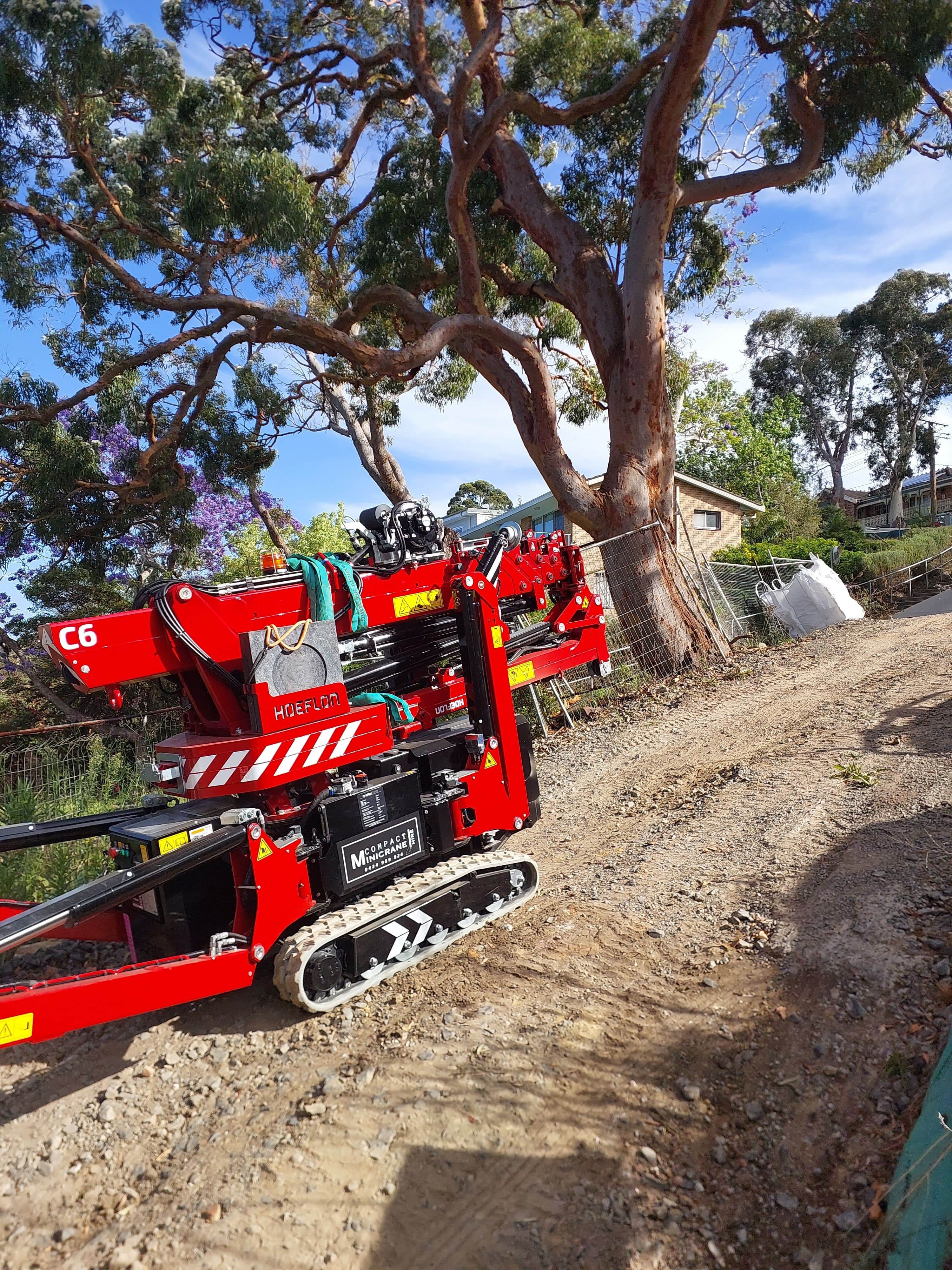 Hoeflon c6 tracking down a dirt track to access to the jobsite.