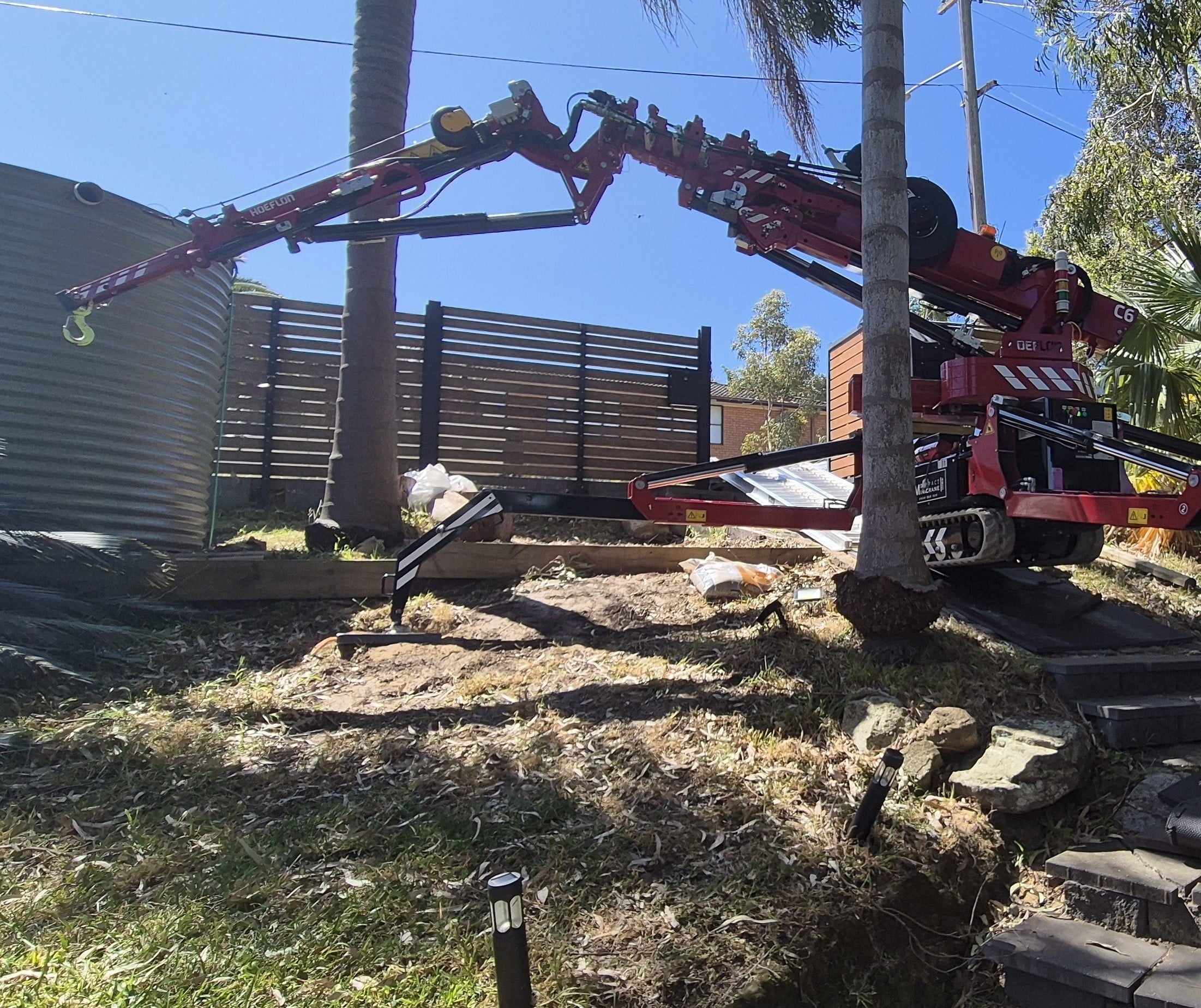 Crane setup on a steep hill to lift & relocate a steel water tank.